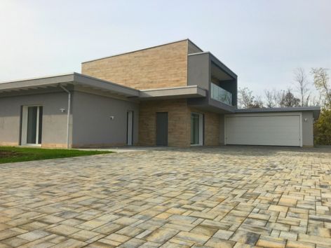 Edificio moderno certificato CasaClima GOLD con sistema costruttivo Bioisotherm. Presenta un design contemporaneo e un'ampia area esterna pavimentata. L'immobile offre elevata efficienza energetica e isolamento termico avanzato, riflettendo i più alti standard di edilizia sostenibile.