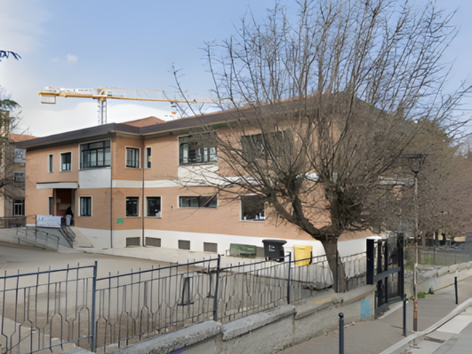 Edificio scolastico Tofare ad Ascoli Piceno, oggetto di adeguamento sismico e miglioramento energetico con tecnologia Argisol di Bioisotherm. Vista esterna dell'edificio con cantiere in corso, gru sullo sfondo e cortile anteriore.